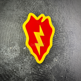 Front view of the 25th Infantry Division taro leaf display insignia lying flat on a dark stone surface