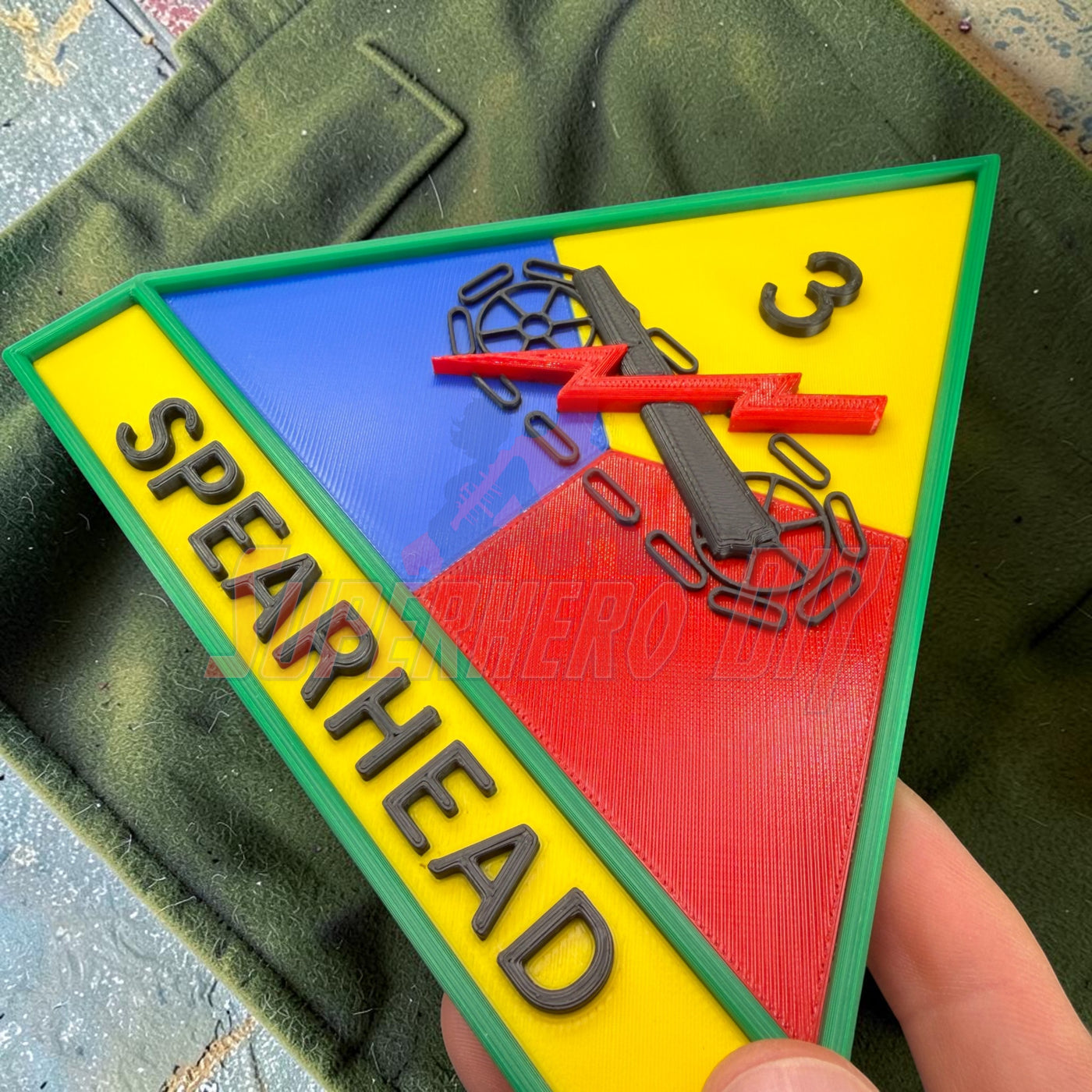 3rd Armored Division display insignia featuring Spearhead logo on a colorful triangular patch.