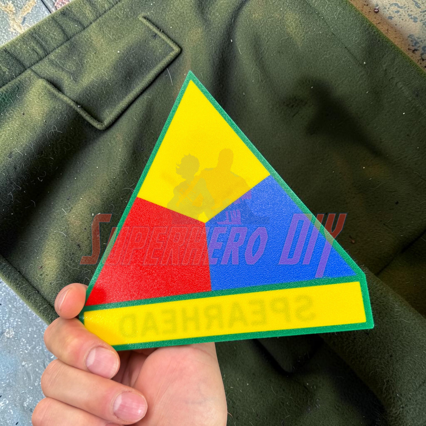 3rd Armored Division display insignia featuring the Spearhead logo in bright colors on a green background.