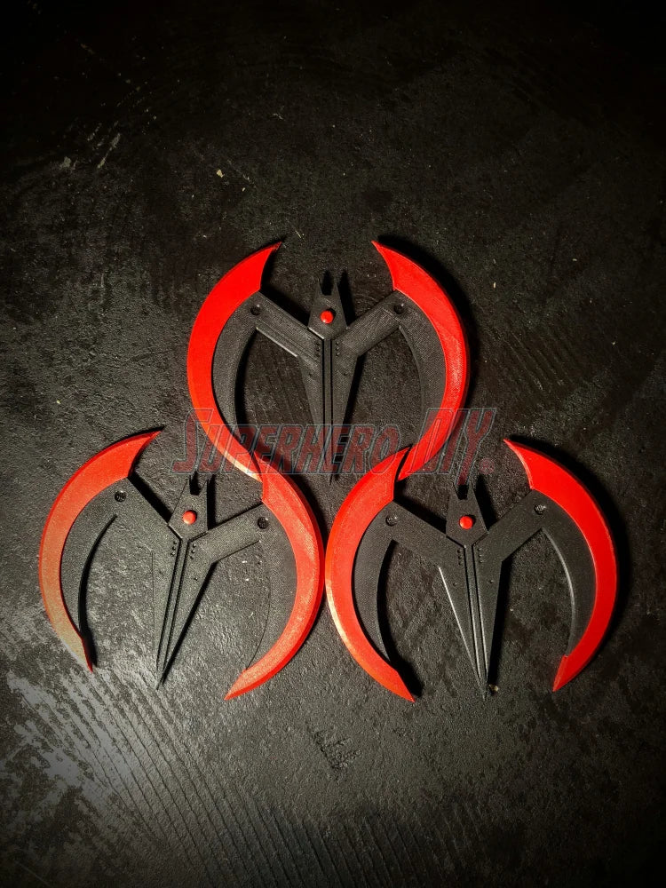 3D-printed Beyond Batarang prop featuring three red and black batarangs arranged on a dark surface