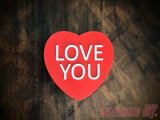 3D-PRINTABLE STL FILE | Candy Heart Gift Box | DIGITAL FILE ONLY - Red candy heart-shaped gift box with white LOVe YOU text on a dark wood surface. - SuperheroDIY