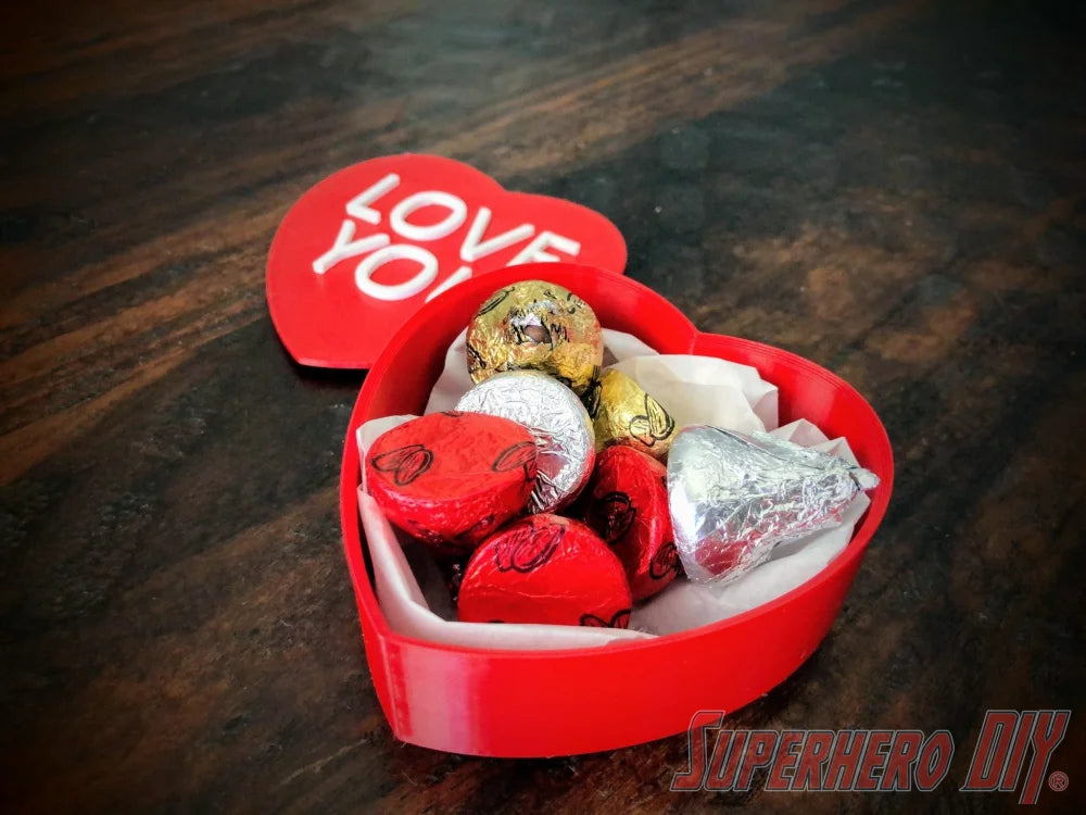 3D-PRINTABLE STL FILE | Candy Heart Gift Box | DIGITAL FILE ONLY - Red heart-shaped gift box filled with assorted wrapped chocolates on a dark wood surface. - SuperheroDIY