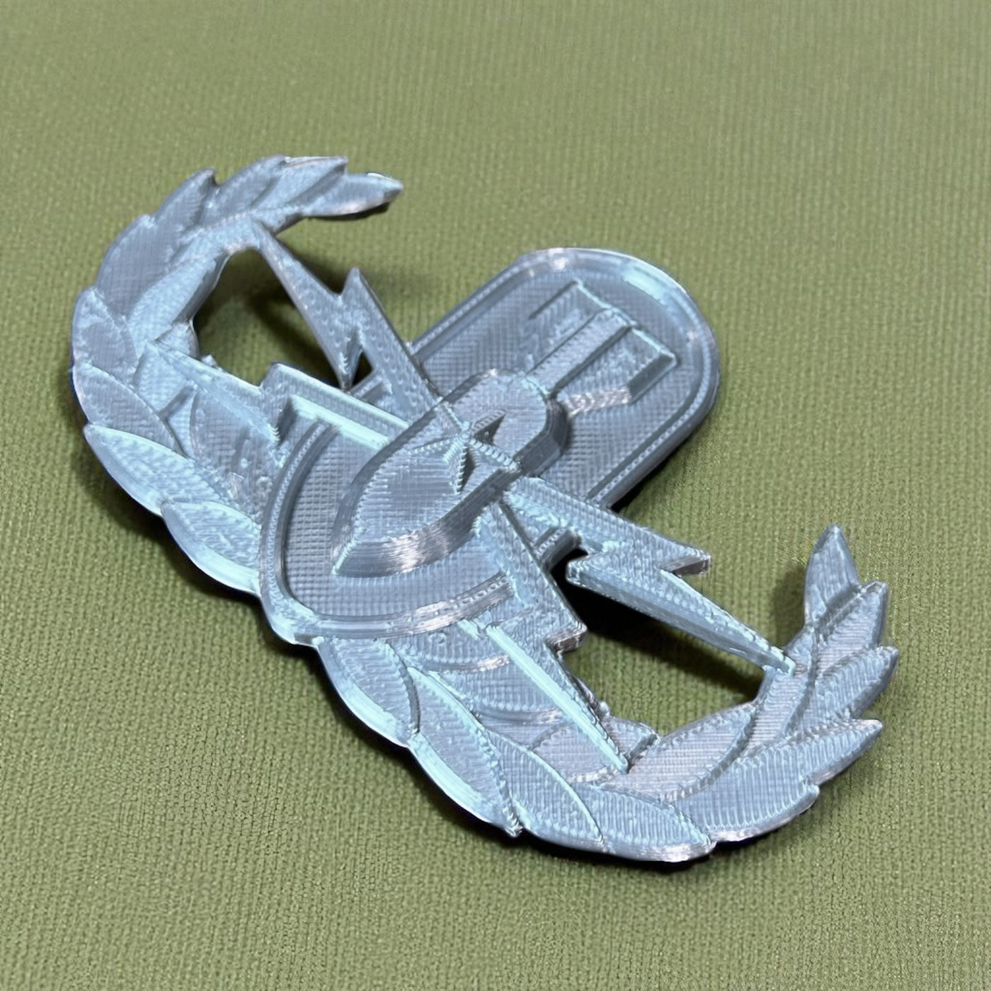 Replica EOD Badge Display in silver, showcasing military achievement and technical skill.
