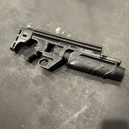 BvS Grenade Launcher Prop Batman v Superman displayed on a textured surface, showcasing its custom design and detailing.