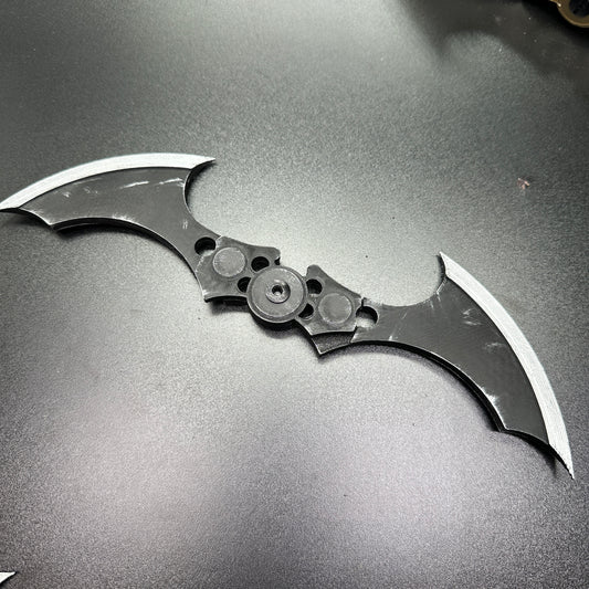Folding Magnetic Batarang - 10” version displayed on a smooth black surface, showcasing its unique design.