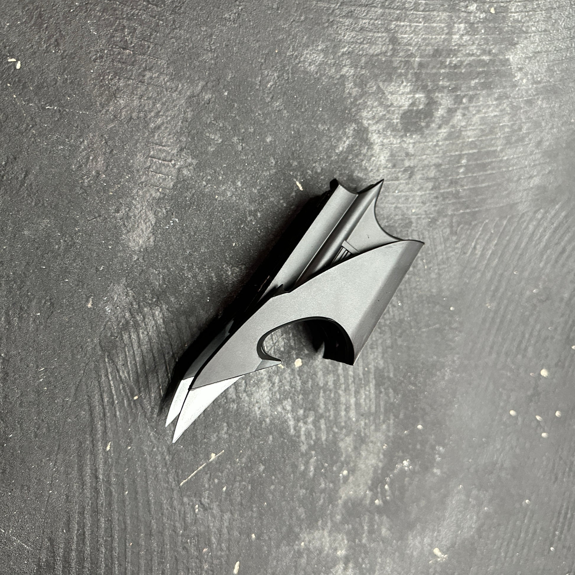 NECA BATMAN 1989 Folding Magnetic Batarang (LOOSE) displayed on a dark surface, showcasing its detailed design.