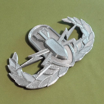 Replica EOD Badge Display showing detailed ornamentation on a green background