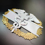 Army medical badge display insignia featuring caduceus and wings on a gold wreath.