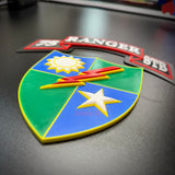 75th Ranger Regiment display insignia on a black surface featuring a colorful shield and text.