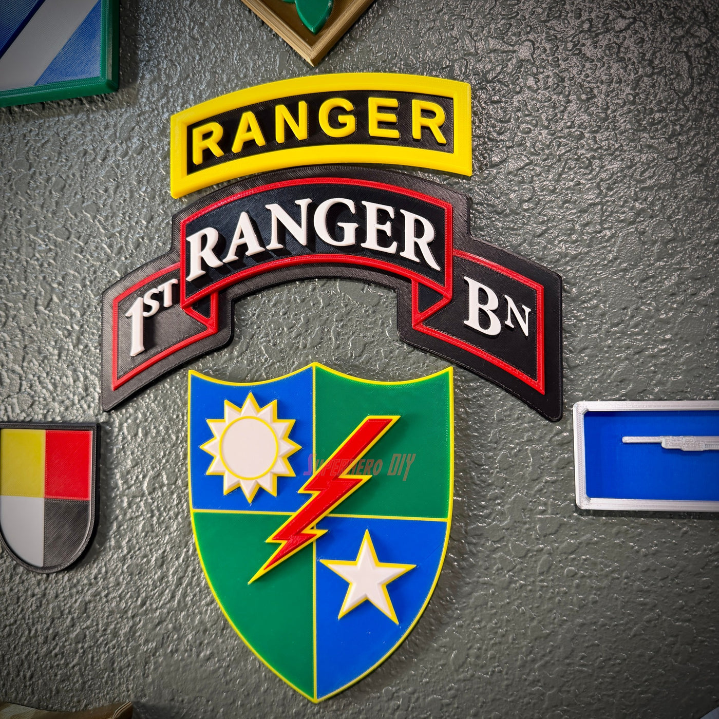 75th Ranger Regiment display insignia with Ranger and 1st Ranger BN patches on a wall.
