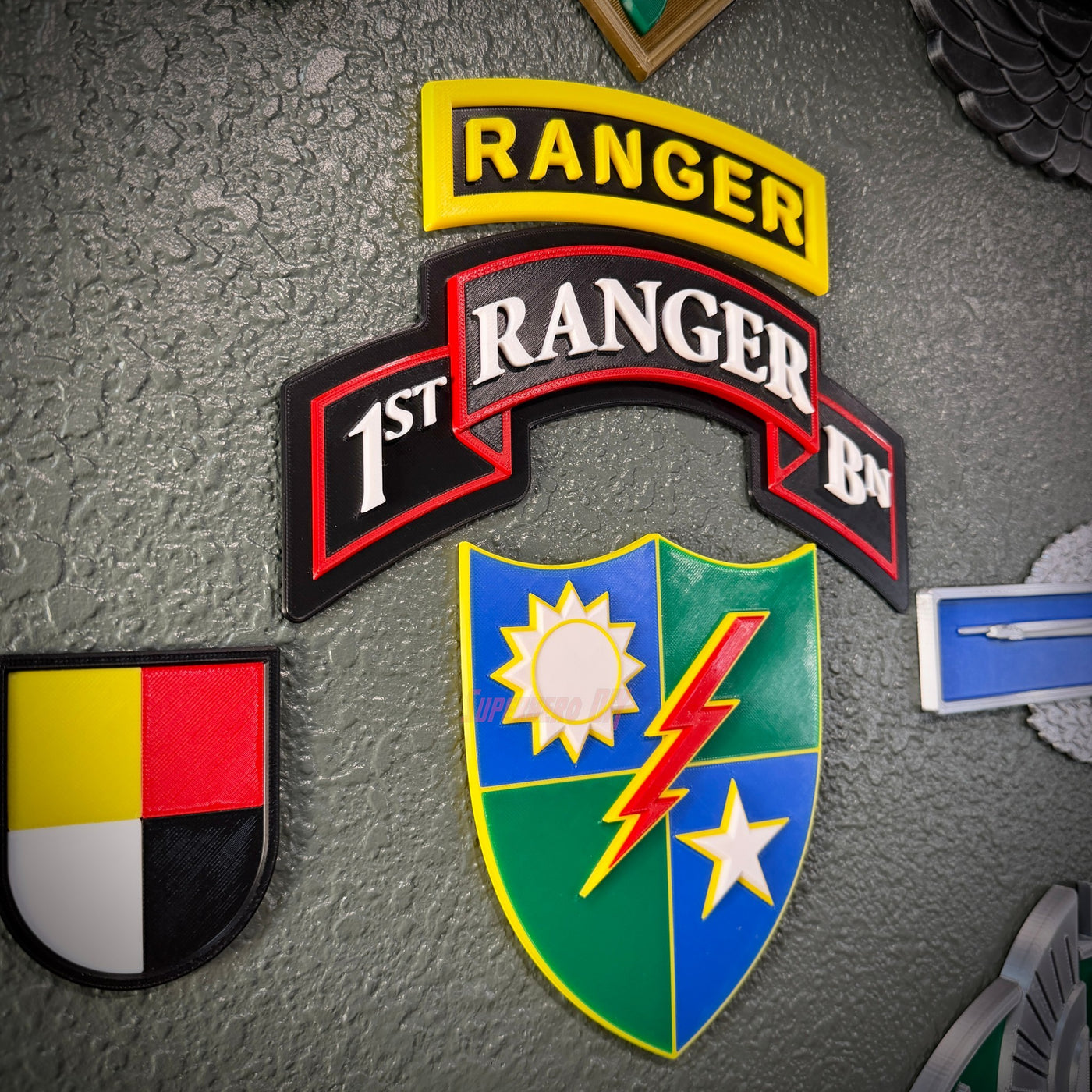 75th Ranger Regiment display insignia featuring 1st Ranger Battalion and Ranger patches on a textured wall.