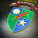 75th Ranger Regiment display insignia showing colorful design with sun, lightning bolt, and star on shield.