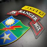 75th Ranger Regiment display insignia featuring colorful patches and tabs on a black background.