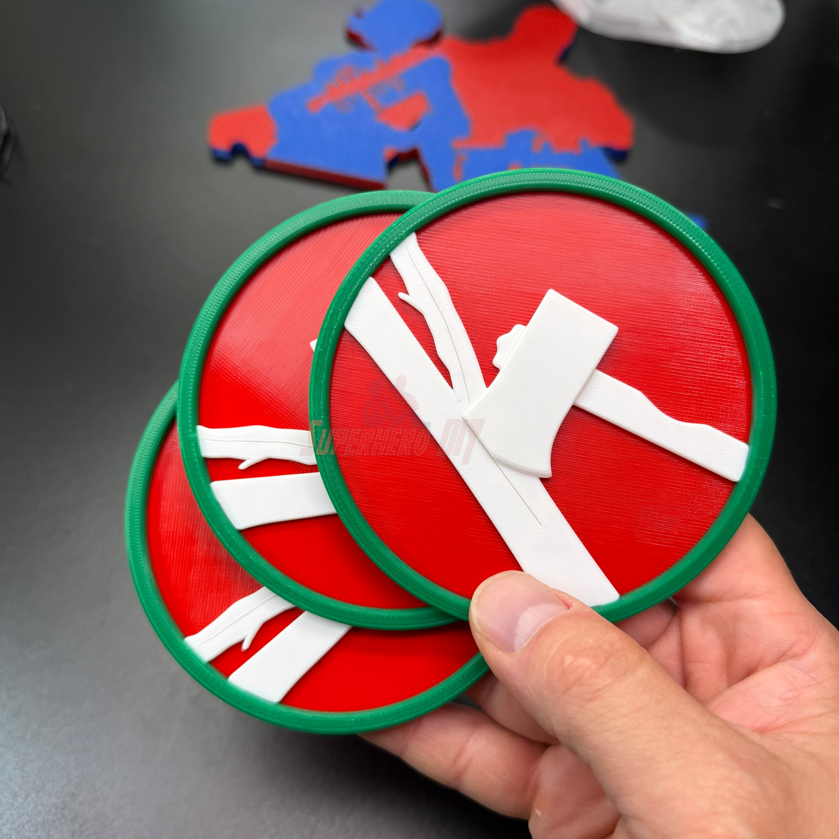 84th Training Command display insignia with white axe on red background, showing three plaques in a hand.