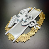 Army medical badge display featuring the Combat Medical Badge design with caduceus and oak leaves.