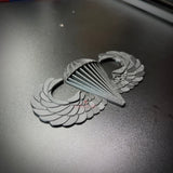 Image of a replica airborne jump wings badge featuring intricate wing and parachute designs.