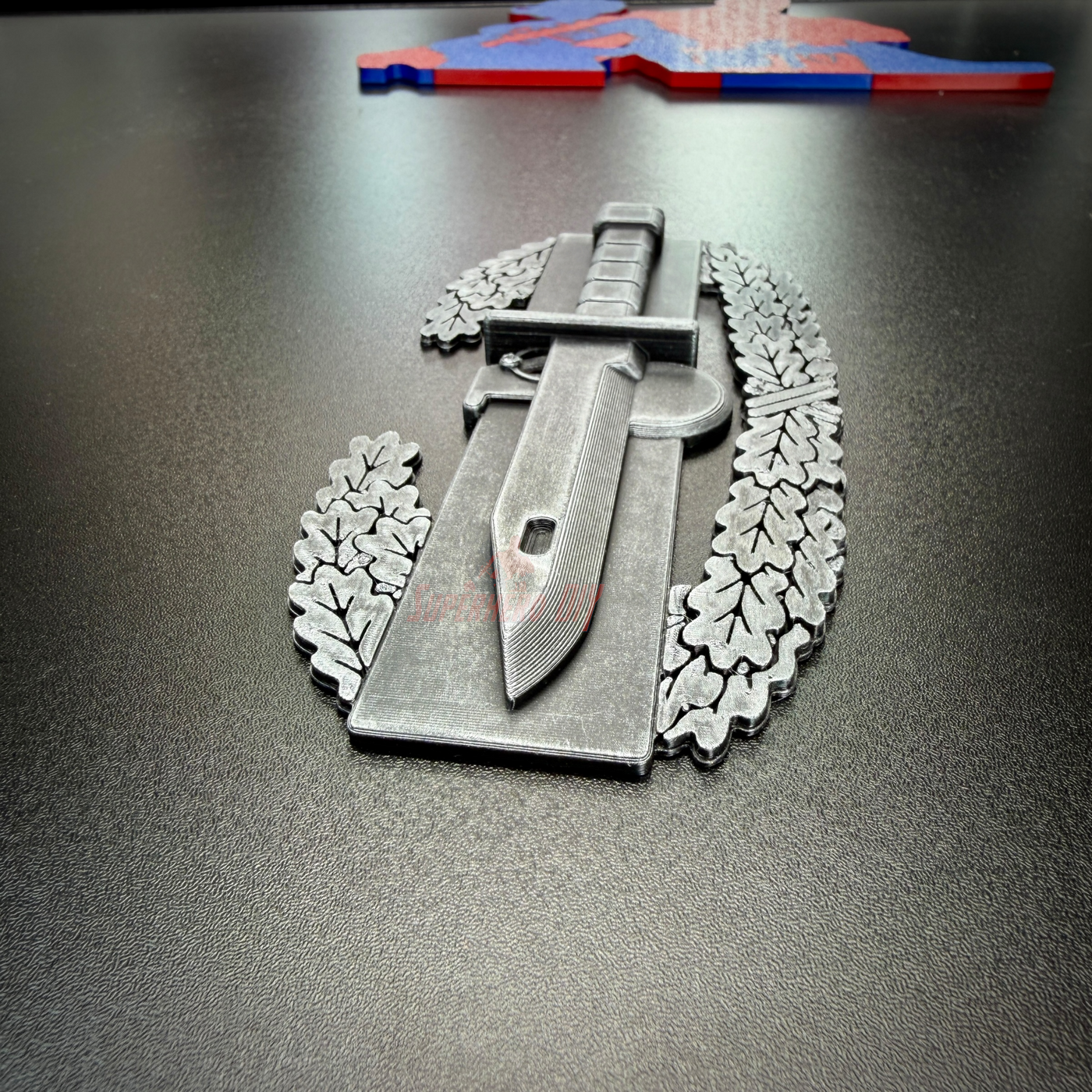 Combat Action Badge with pewter finish, featuring a sword and laurel design, ideal for display.