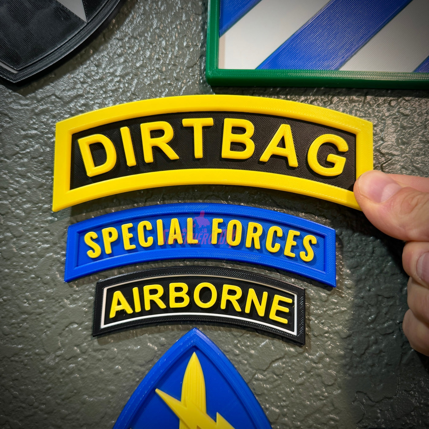 Dirtbag tab badge displayed on a wall alongside Special Forces and Airborne patches.