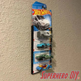 hot wheels wall display sleeve showing 5 blister-packed 1:64 scale cars mounted on a textured wall
