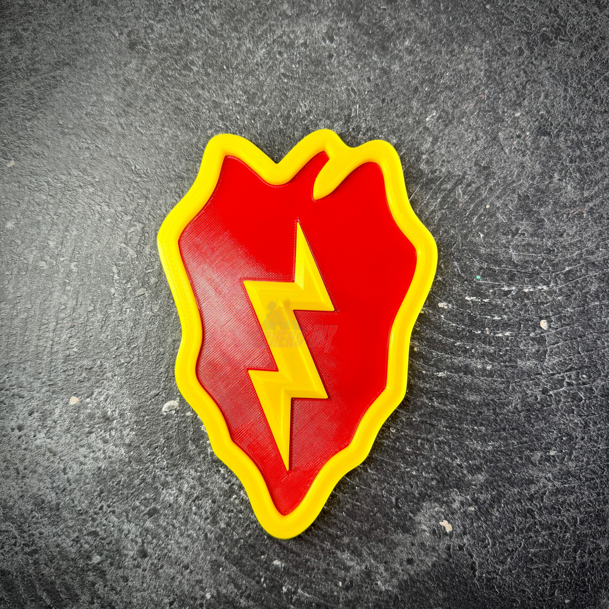 Close-up of the 25th Infantry Division Tropic Lightning insignia, yellow bolt down the center of the red leaf