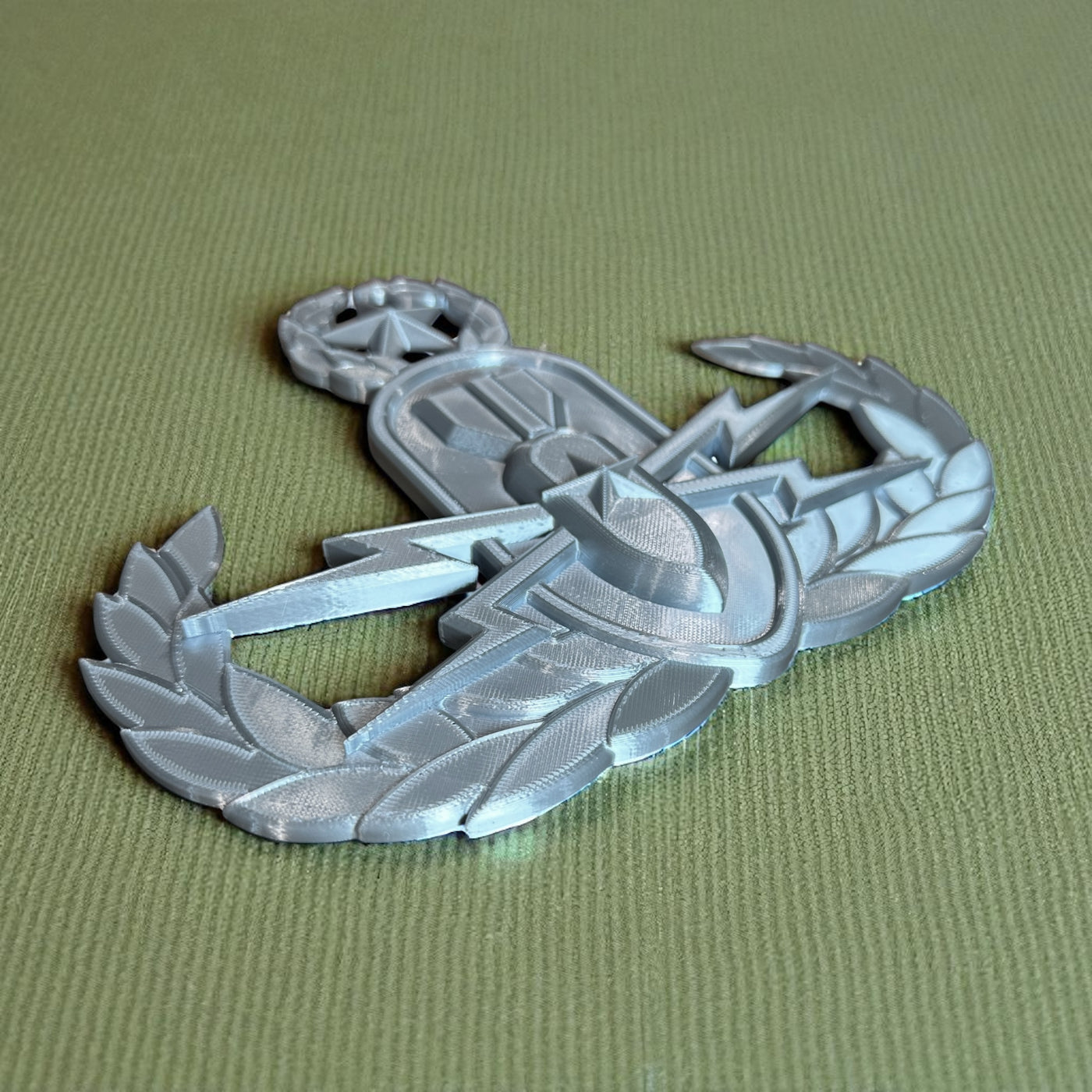 Replica EOD Badge Display showcasing basic, senior, and master levels on a textured green background.