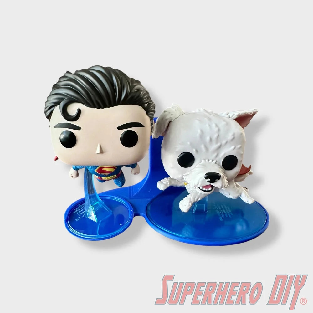 Blue floating shelf holding Funko Pop figures of Superman #562 and Krypto #565 with round bases. - SuperheroDIY