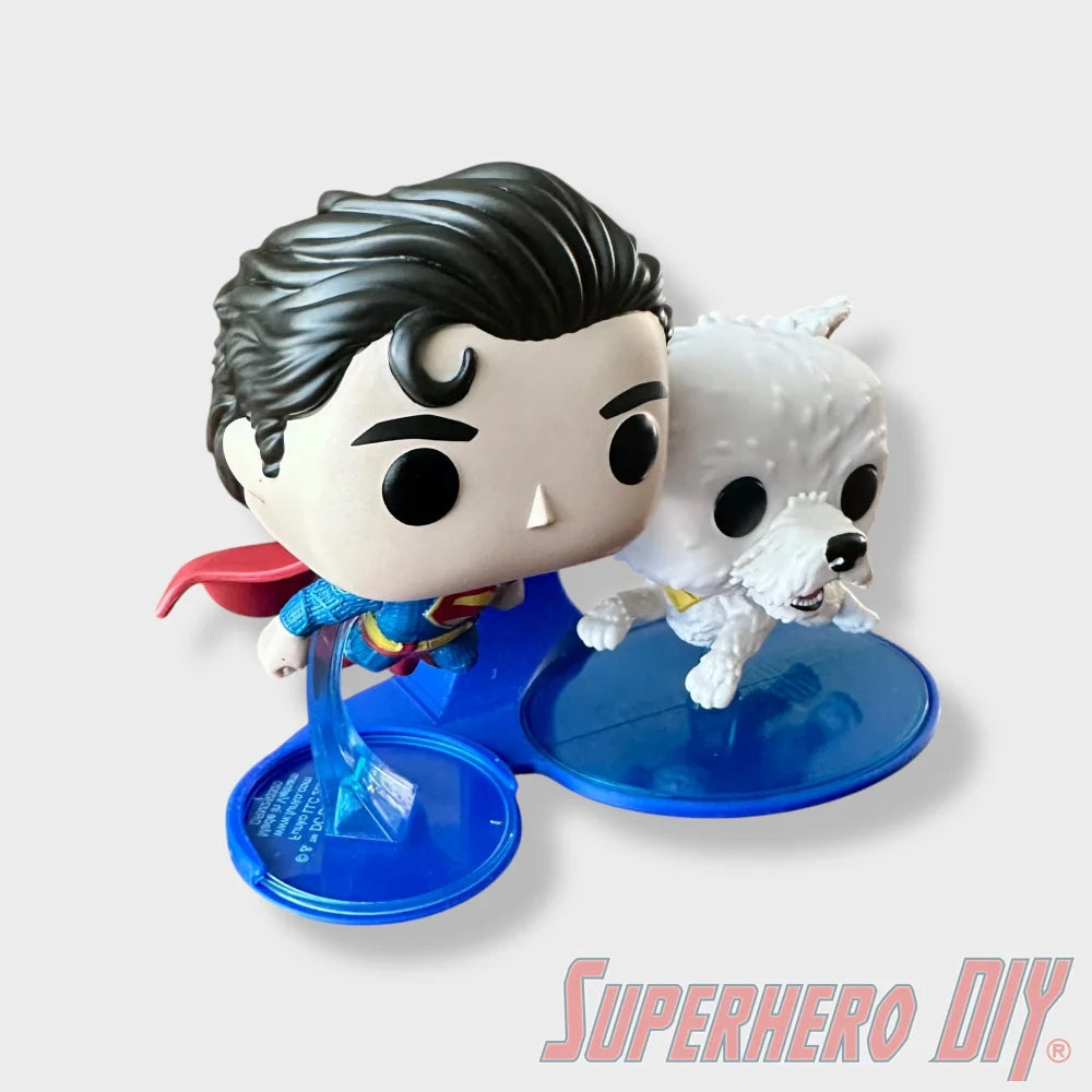Blue floating shelf display holding Funko Pop Superman #562 and Krypto #565 with a red cape and black hair. - SuperheroDIY