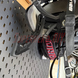 Hockey skater helmet with straps, mounted with a Superhero DIY Helmet Hanger, attached to an IKEA pegboard with Warrior hockey gloves in the background