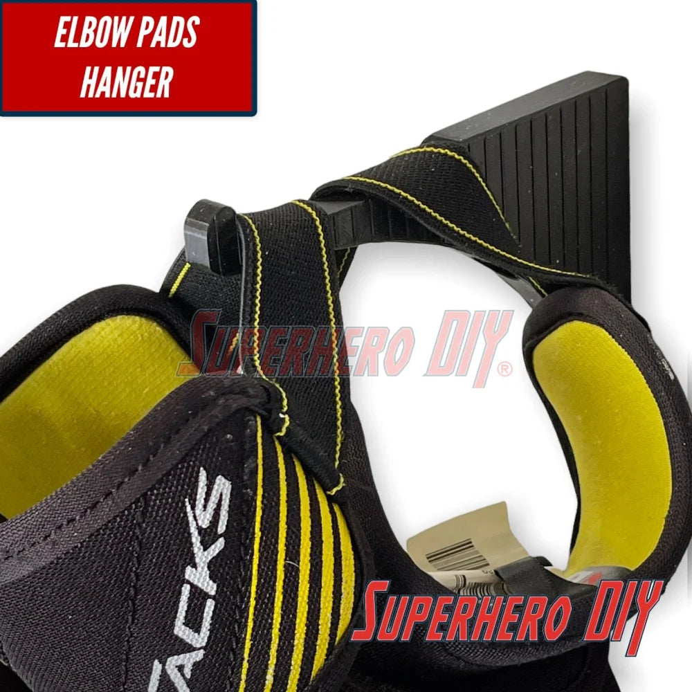 Wall-mounted hockey gear organizer featuring elbow pads hanger for easy storage and access.