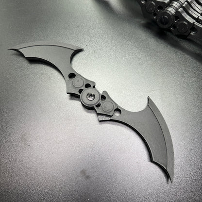 Close-up of MAGNETIC Folding Arkham Batarang Cosplay Prop - 10" version on dark surface, showcasing open position and sharp design.