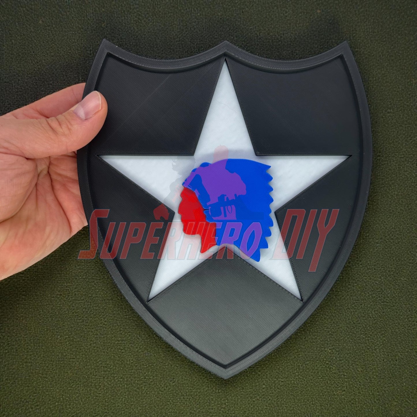 Hand holding 2nd Infantry Division display insignia, a black and white 3D-printed patch for military wall displays.