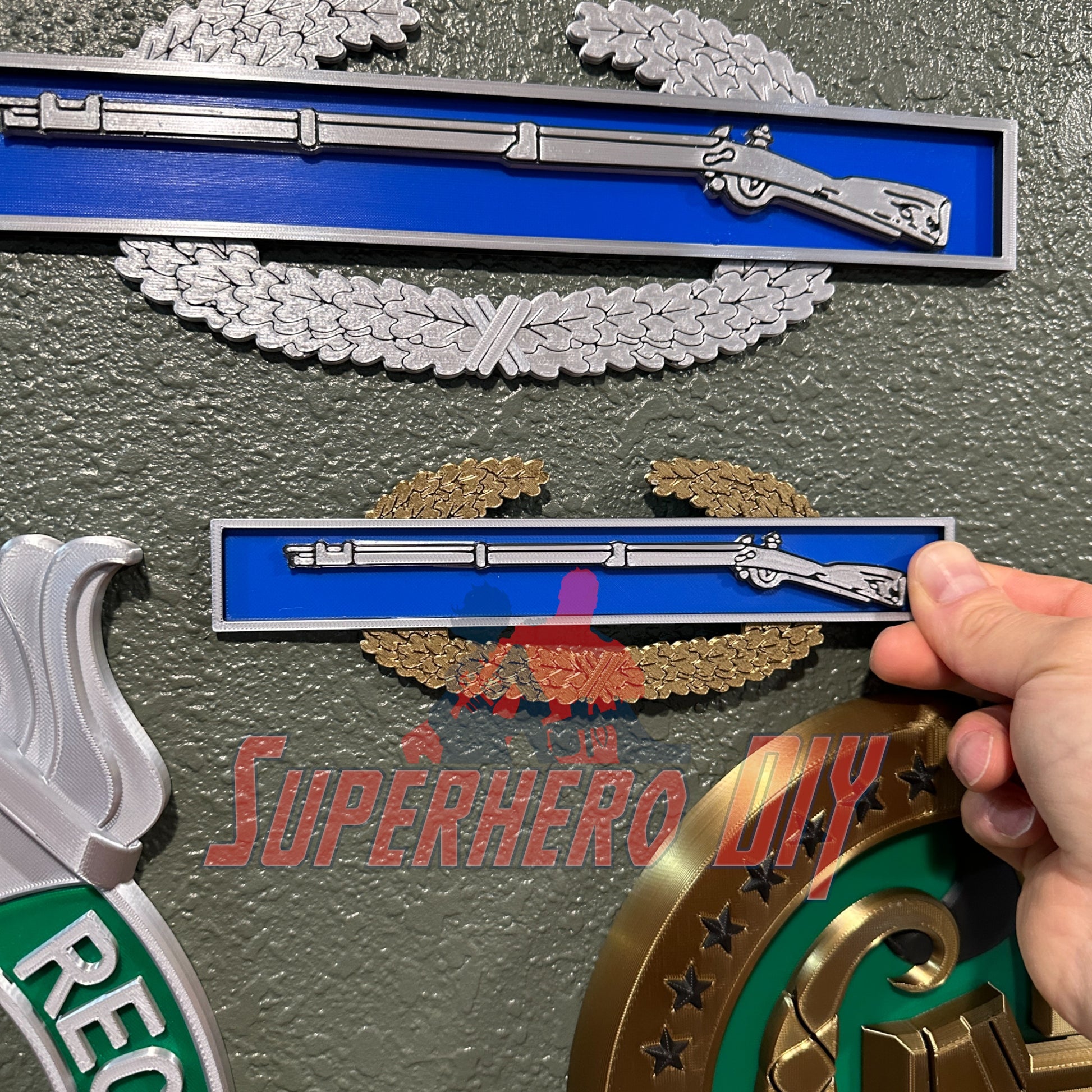 3D-printed Expert Infantryman Badge (EIB) Replica, Combat Infantryman Badge (CIB), and Master Combat Infantryman Badge (MCIB) on display