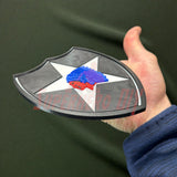 Person holding a 3D-printed 2nd Infantry Division display insignia, showcasing the design for shadowboxes or wall displays.