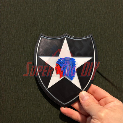 3D-printed 2nd Infantry Division display insignia held in hand, showcasing shield design with star and Native American head, multiple sizes.