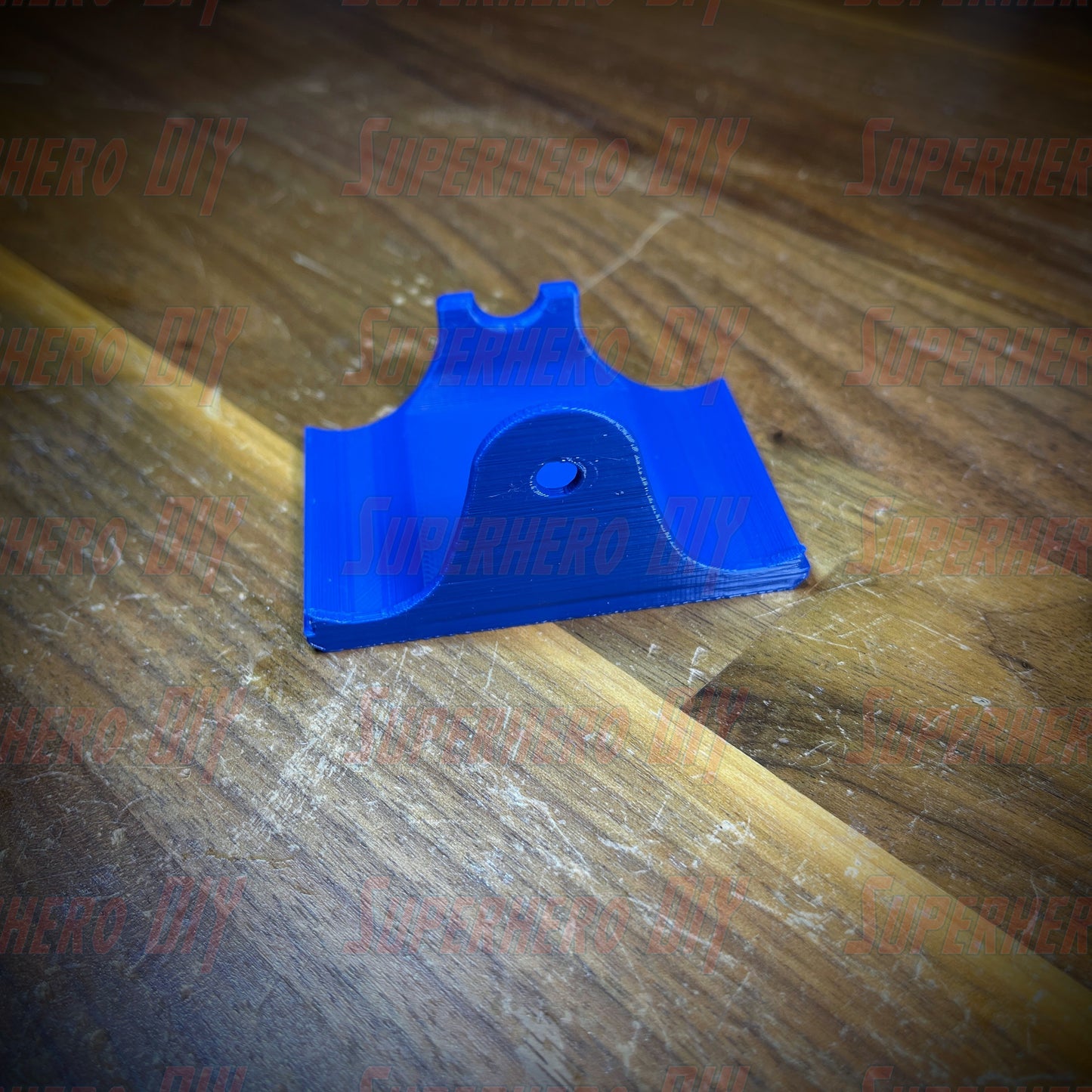 Blue PS4 controller wall mount on a wooden surface, designed for DualShock controllers with included Command Strip for easy mounting.