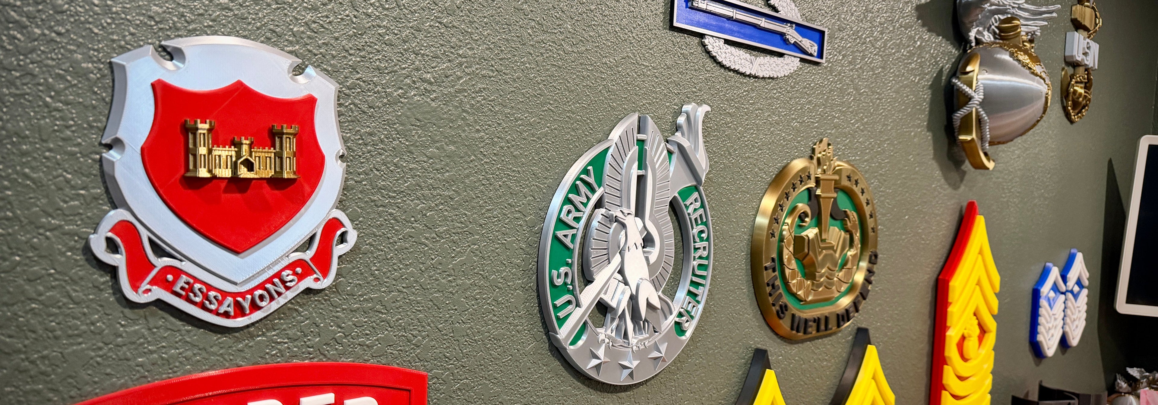 Collection of military insignias and badges on a gray wall.