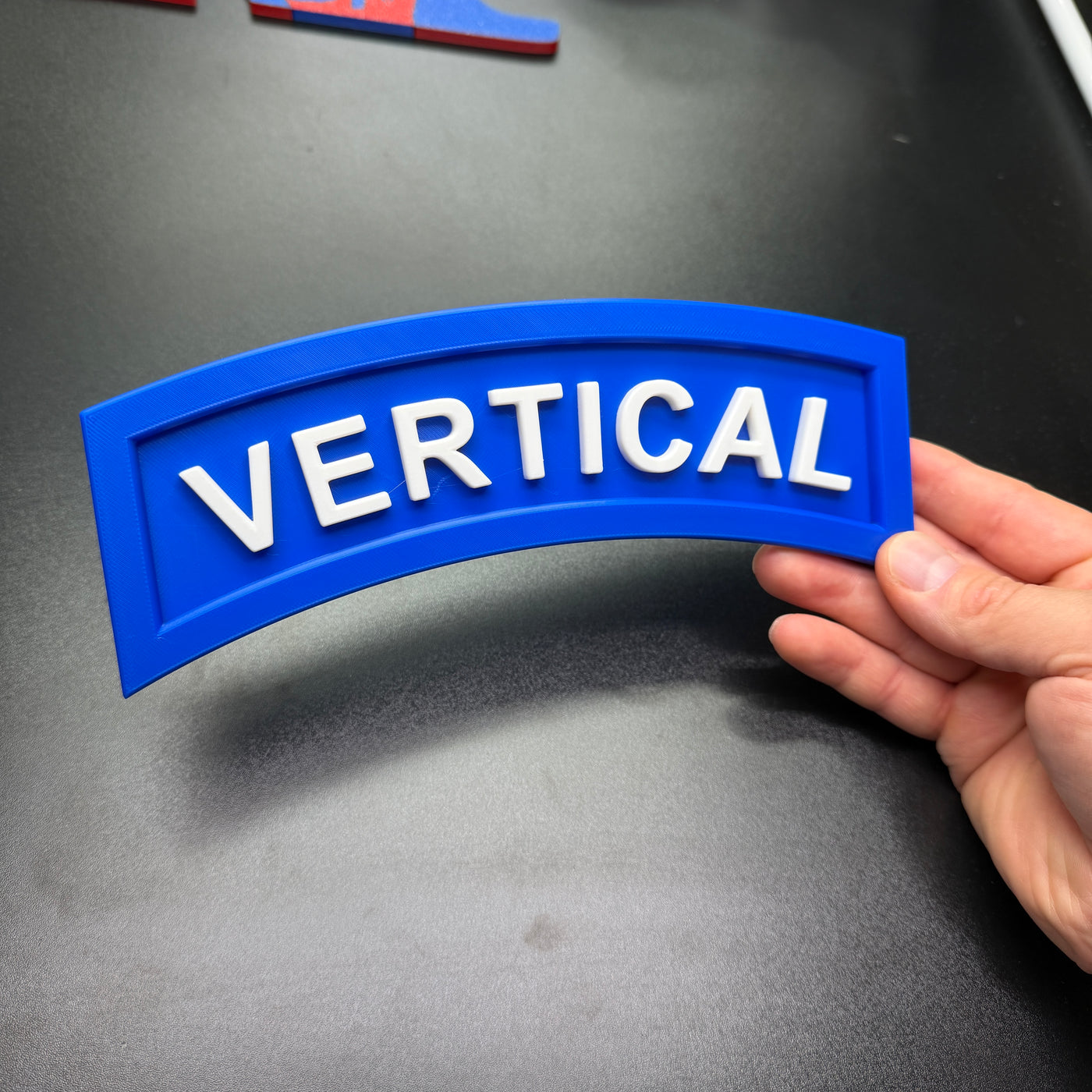 3D vertical construction engineer tab displayed in blue with white letters spelling 'VERTICAL'.