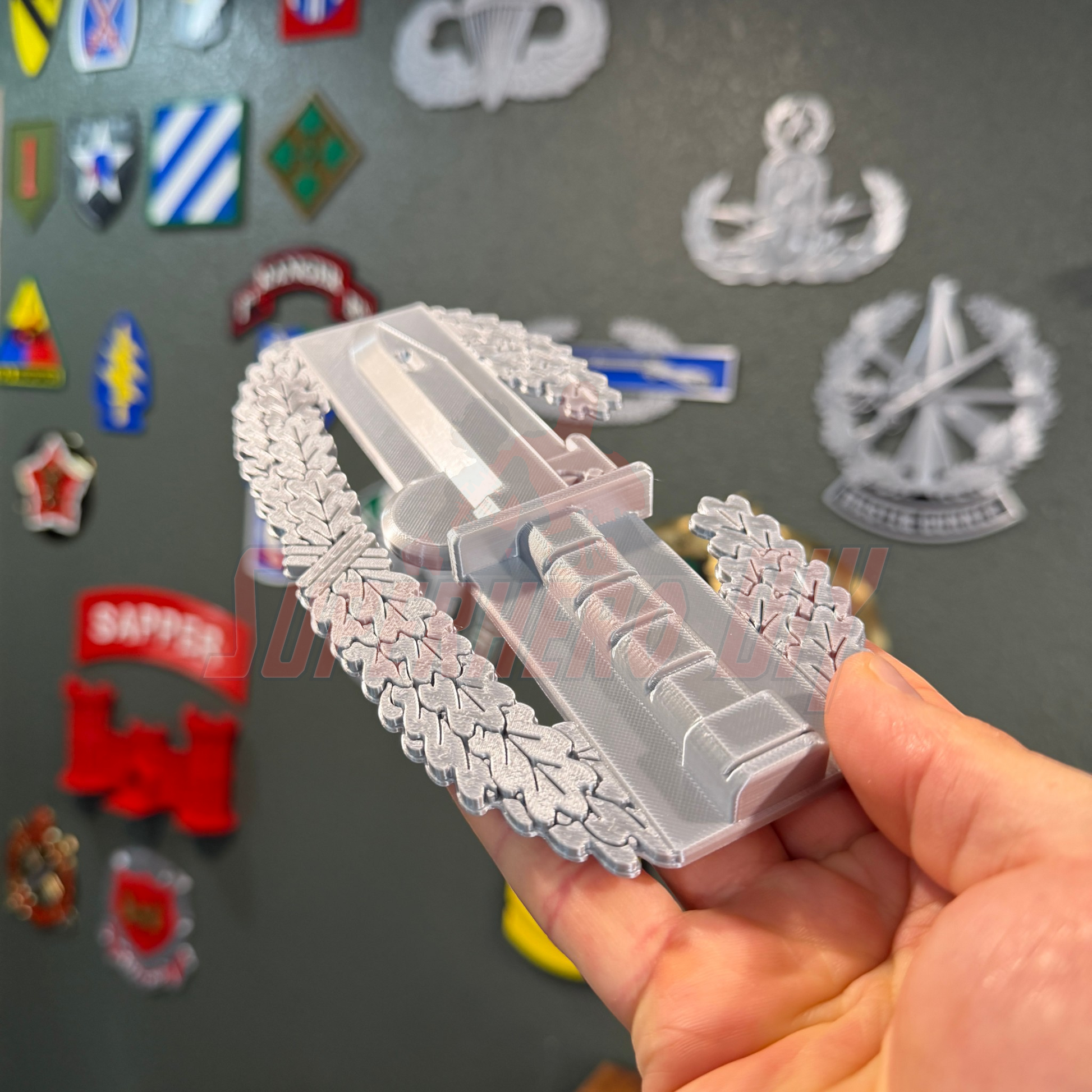 Combat Action Badge display held in hand, featuring intricate details and designed for wall or desk presentation.