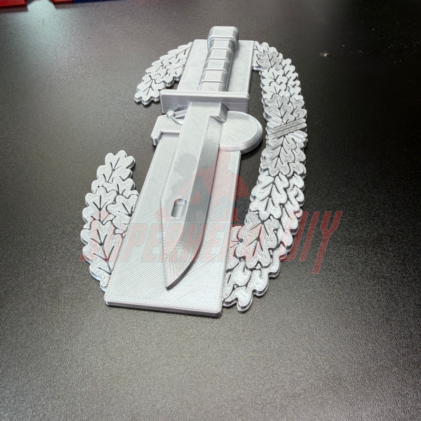 Combat Action Badge display insignia featuring a bayonet and oak wreath, perfect for wall or desk display.