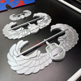 Air Assault Badge display insignia pieces featuring shiny silver wings and secure fasteners.
