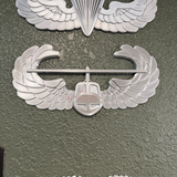 Air Assault Badge display insignia mounted on a wall, showcasing shiny silver finish and wings design.