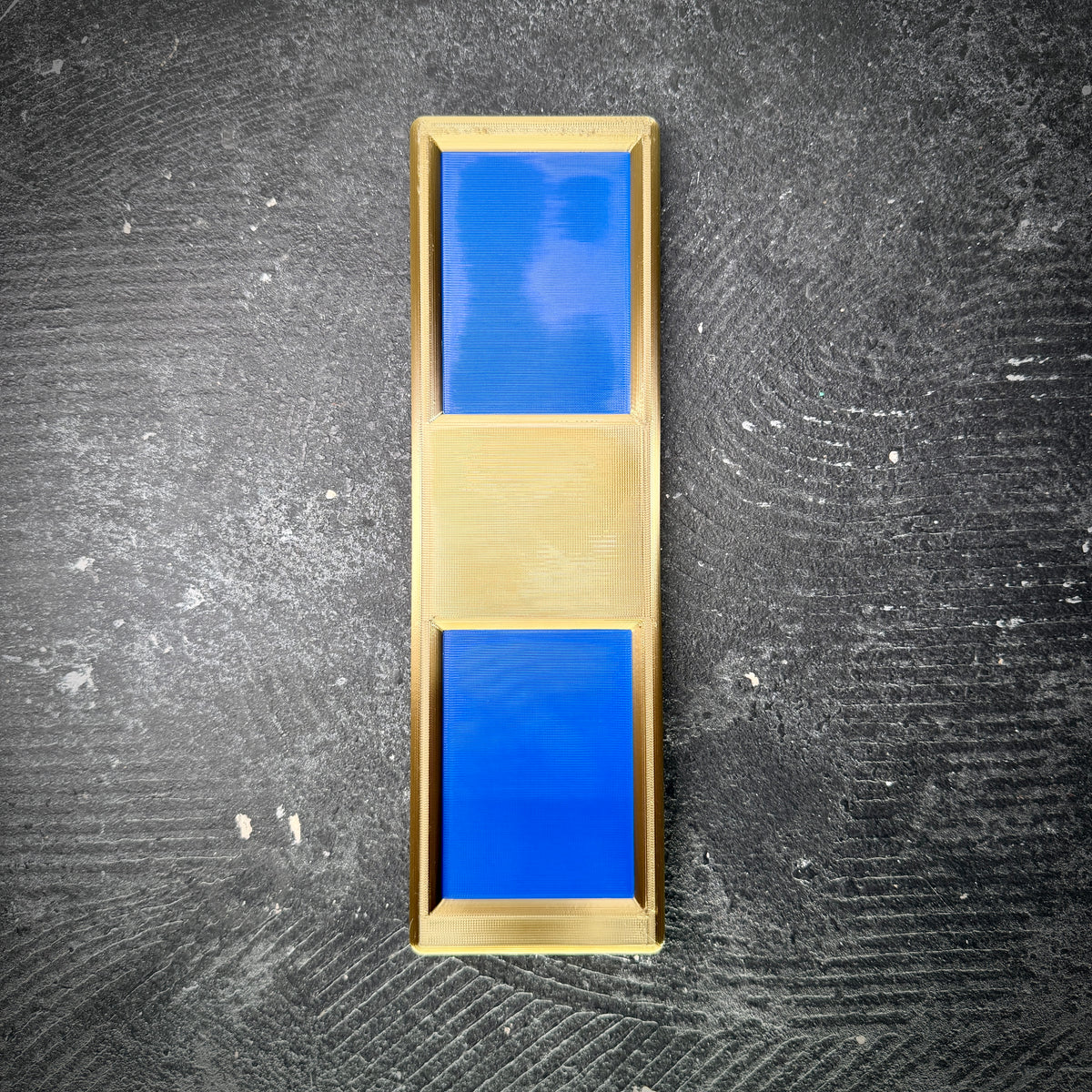 Navy WO1 insignia in gold and blue, displayed on a black concrete floor.