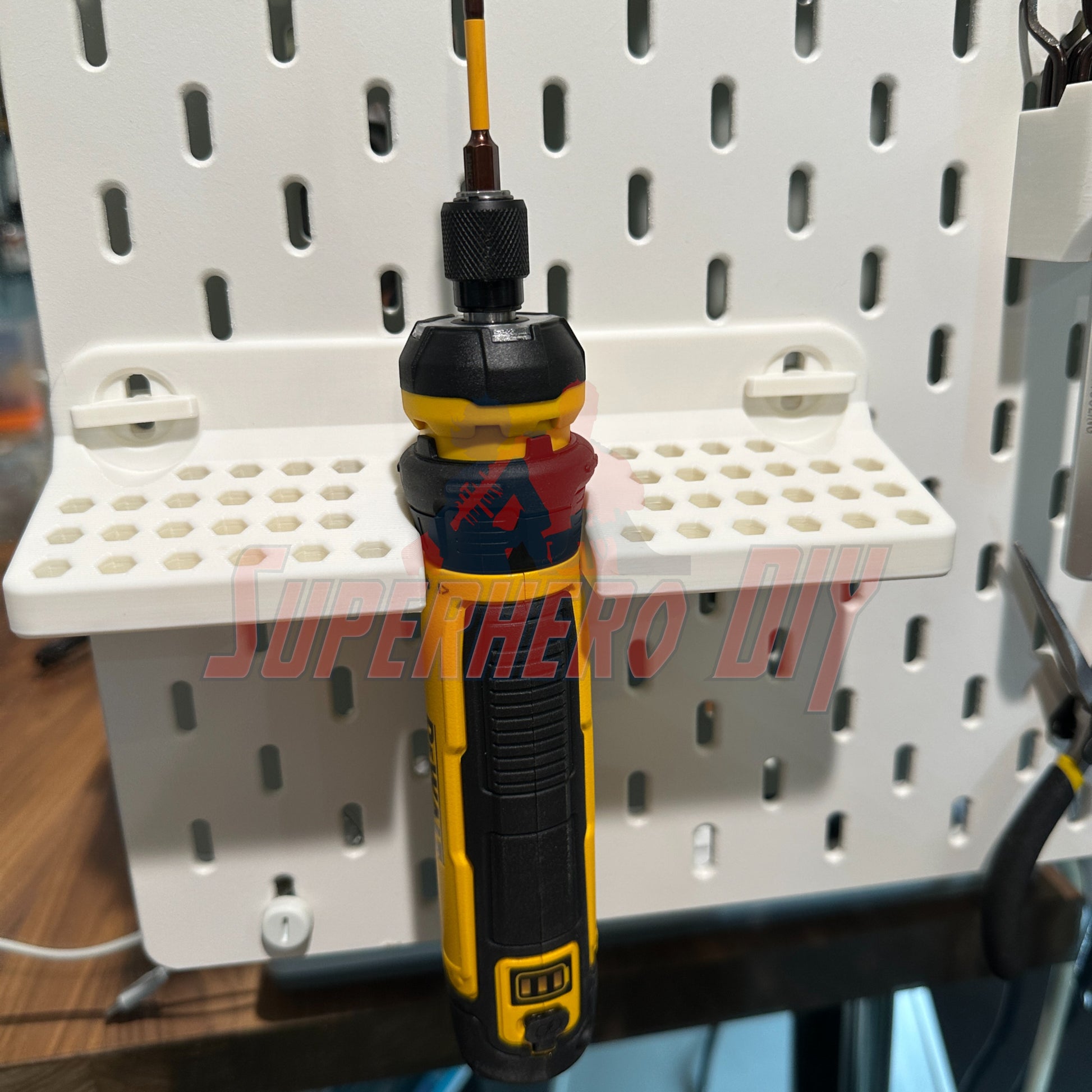 DeWalt cordless screwdriver organizer wall-mounted SKADIS with screwdriver attached for easy tool access.