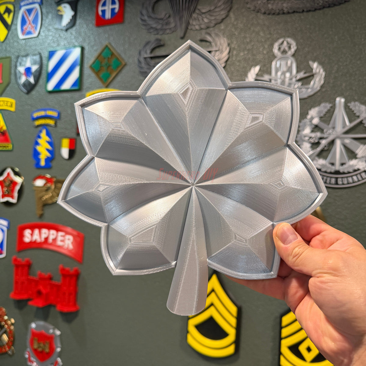 Detailed military officer rank insignia replica displayed in hand, showcasing glossy finish and design.