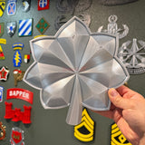 Detailed military officer rank insignia replica displayed in hand, showcasing glossy finish and design.