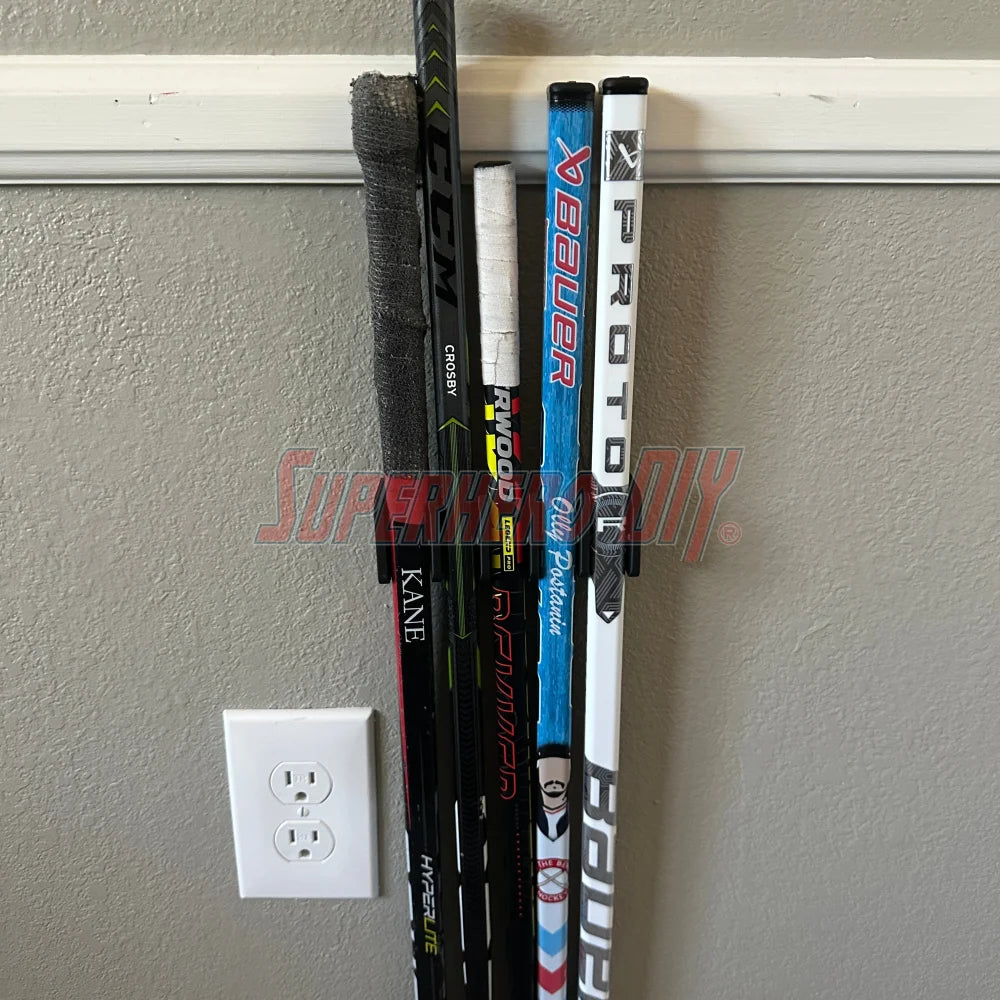 MINI Stick Holder Wall Mount organizing knee hockey sticks on a wall, featuring space for five or ten mini stick holders.