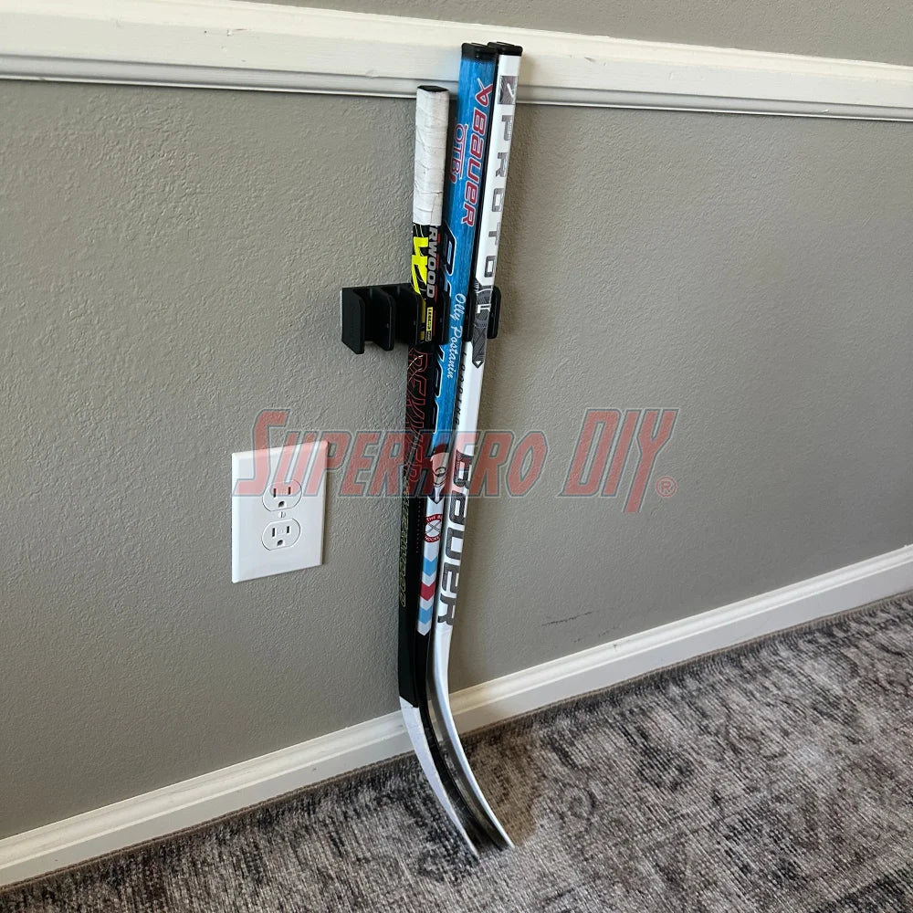 Wall-mounted mini stick holder organizing knee hockey sticks.