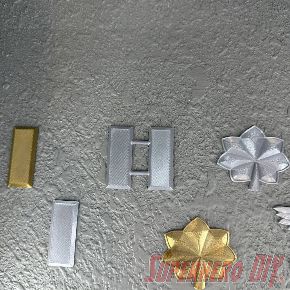 O-4 Major Navy lieutenant commander rank insignia in various colors and designs on a textured surface.