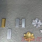 O-4 Major Navy lieutenant commander rank insignia in various colors and designs on a textured surface.