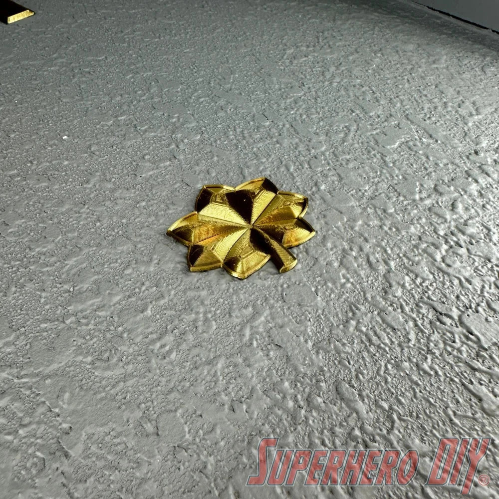 O-4 Major Navy lieutenant commander rank insignia in bold gold finish on a textured gray surface.